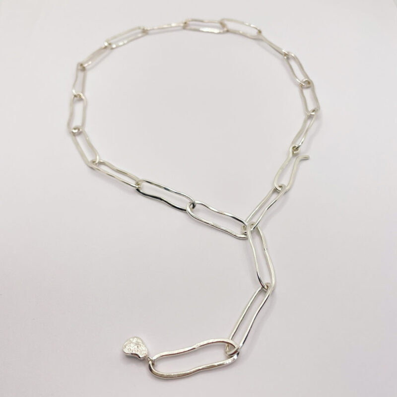 Collana a catena, elementi in argento ovali irregolari, concatenati con piccolo ciondolo finale