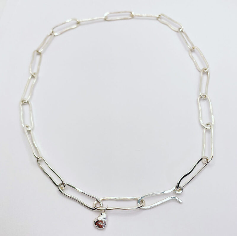 Collana a catena, elementi in argento ovali irregolari, concatenati con piccolo ciondolo finale