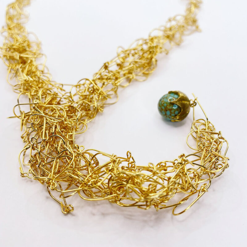 Collana realizzata con monachelle in ottone dorato e perla di vetro